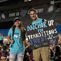 Student at transitions holds a sign reading "Anchor Up for Transitions"